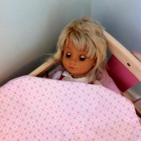 בובה נחה במיטת הבובות